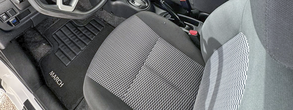 Car interior with detailed view of driver's seat and floor mat labeled